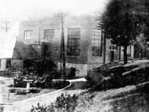 Historic black-and-white photo of the power plant building exterior.
