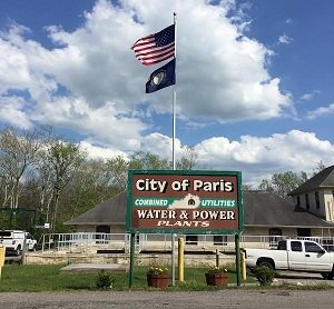 City of Paris Combined Utilities Water and Power Plants sign with flags flying above it.