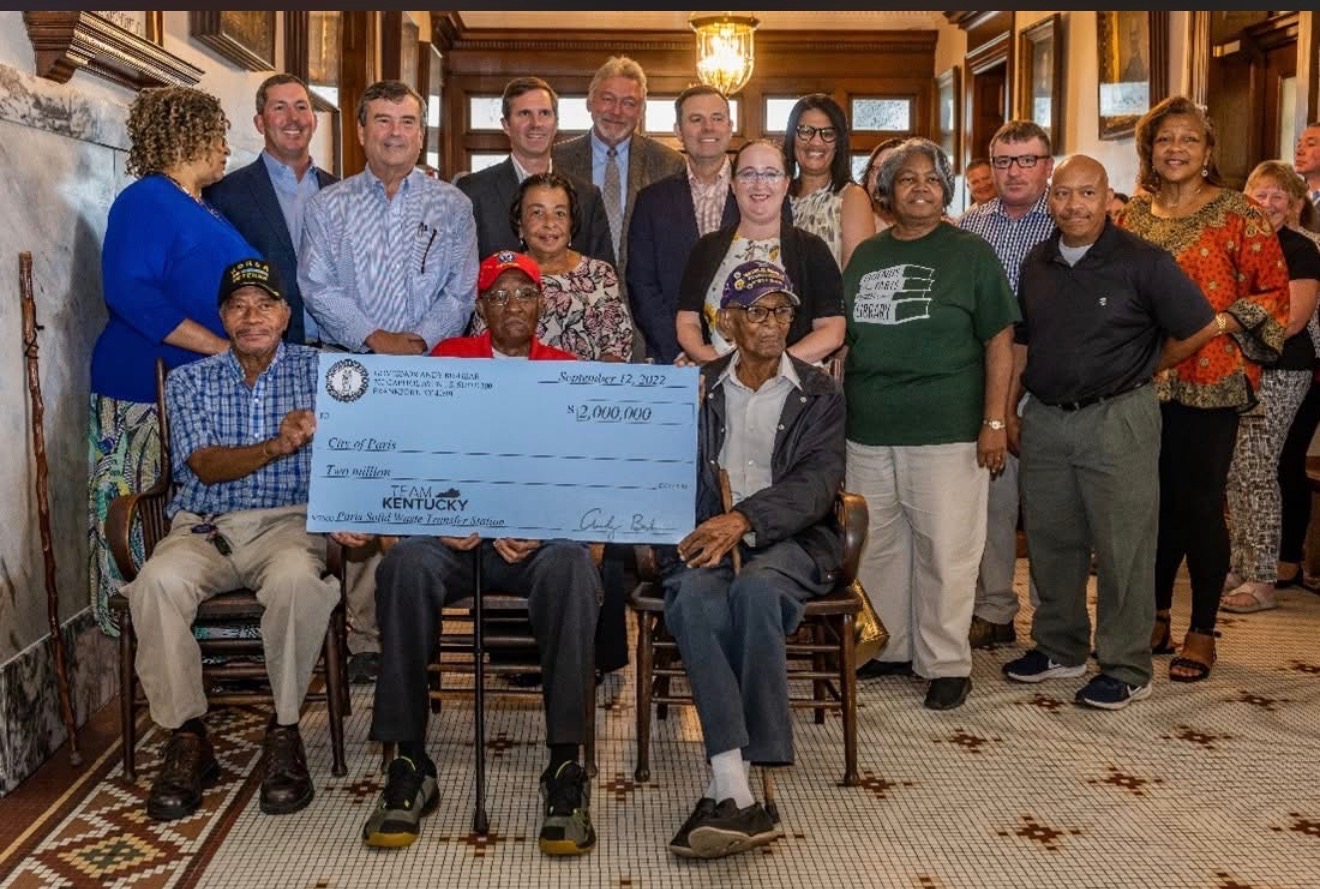 A large group gathered for the presentation of a ceremonial $2 million grant check, with several people holding the check in front.
