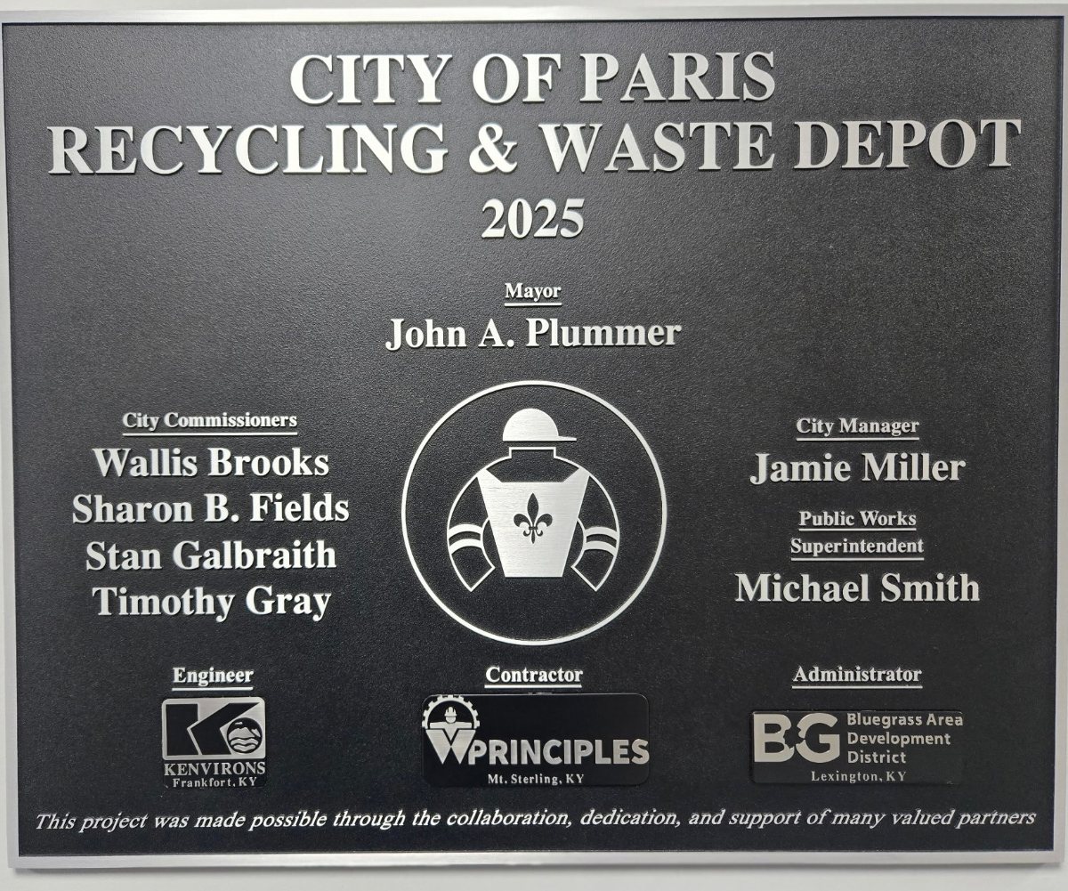 Dedication plaque reading City of Paris Recycling & Waste Depot, 2025, listing Mayor John A. Plummer, City Commissioners Wallis Brooks, Sharon B. Fields, Stan Galbraith and Timothy Gray, City Manager Jamie Miller, Public Works Superintendent Michael Smith, and the engineer, contractor and administrator.